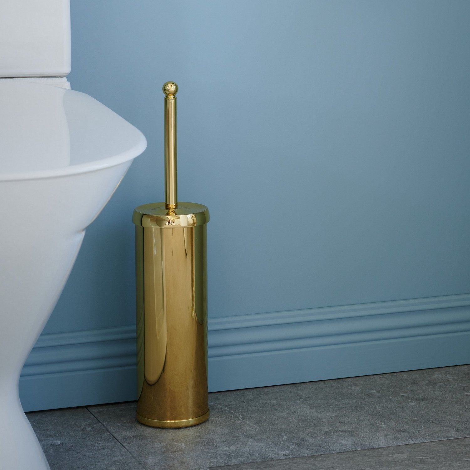 V233 Smedbo Villa Polished Brass Freestanding Toilet Brush and Holder Next to a Toilet Pan